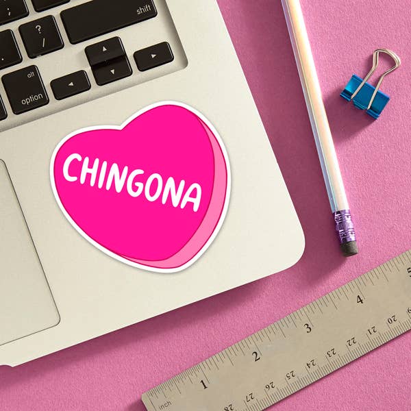 Hot pink heart-shaped Chingona die cut sticker displayed on a laptop trackpad