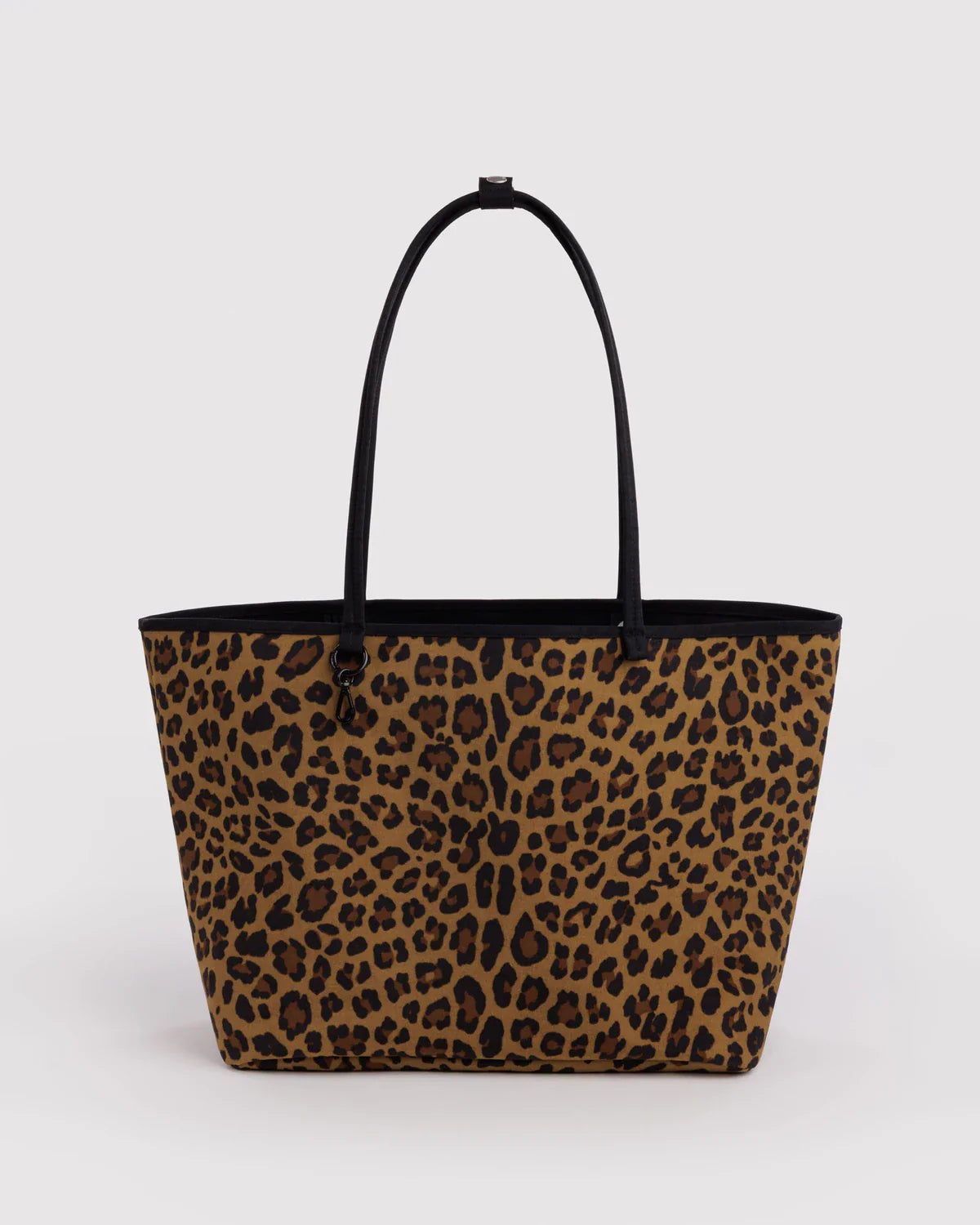 Large nylon reversible tote bag in leopard print with black handles on white background