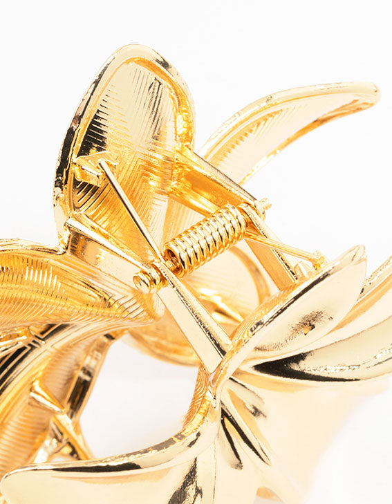 Gold metallic flower-shaped hair claw clip with petal design and spring mechanism