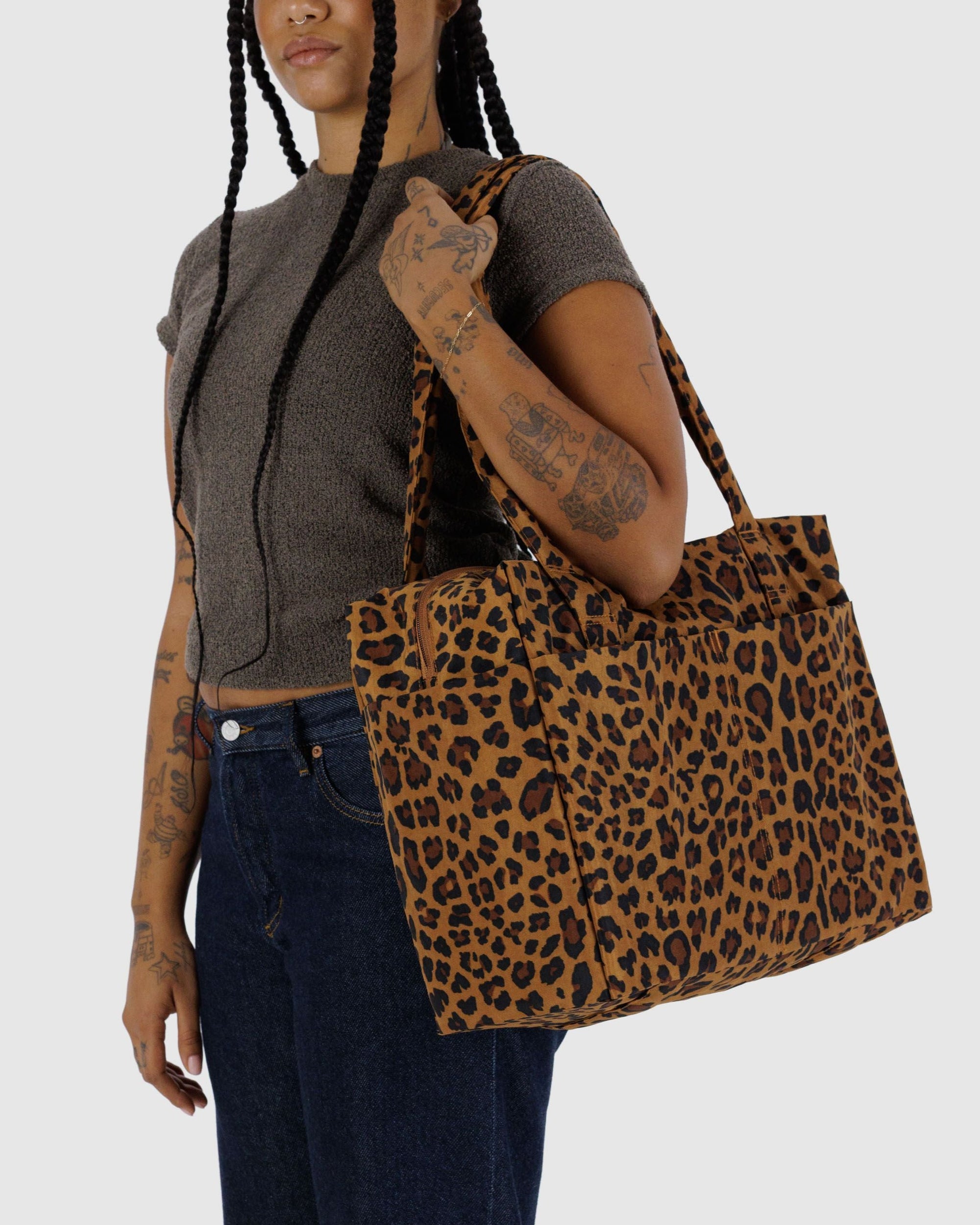 Model wearing leopard print carry-on bag with laptop pocket over shoulder
