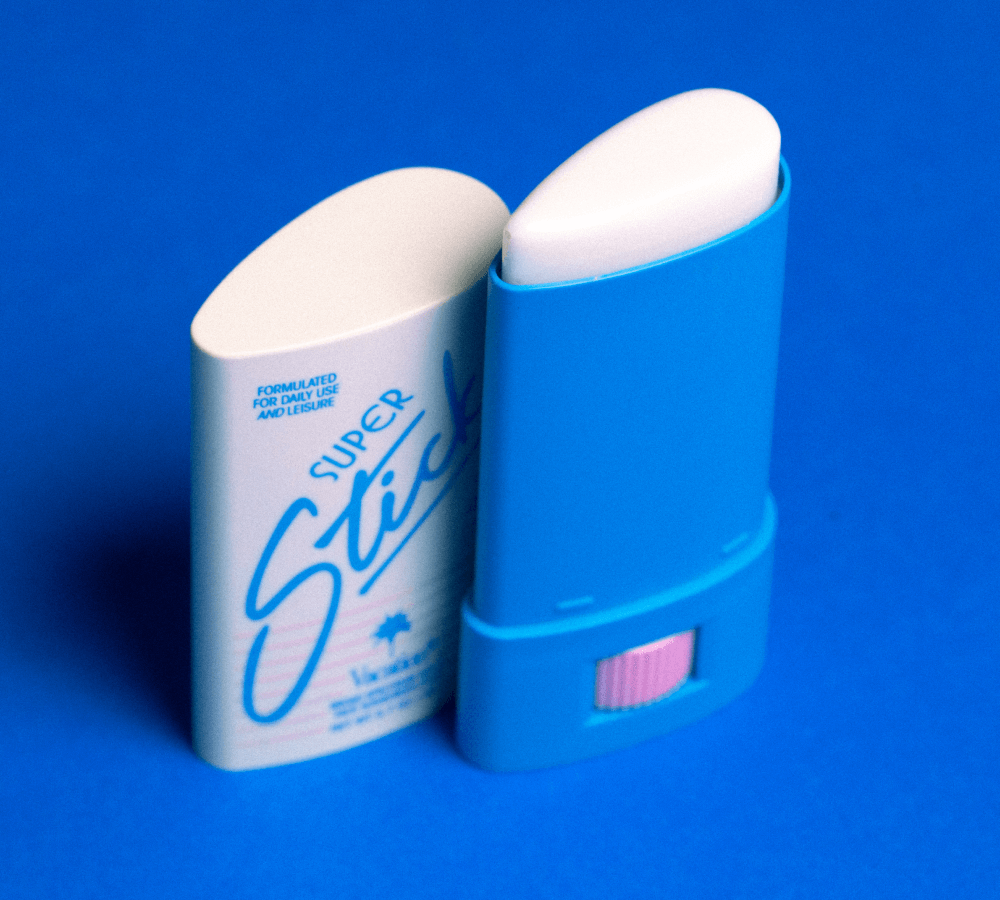 Two Vacation Super Stick sunscreen products on blue background, one showing front label