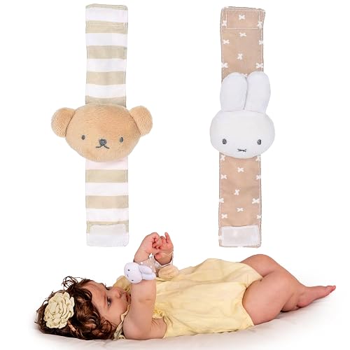 Baby lying down wearing Miffy bunny wrist rattle with bear and bunny rattle set displayed above