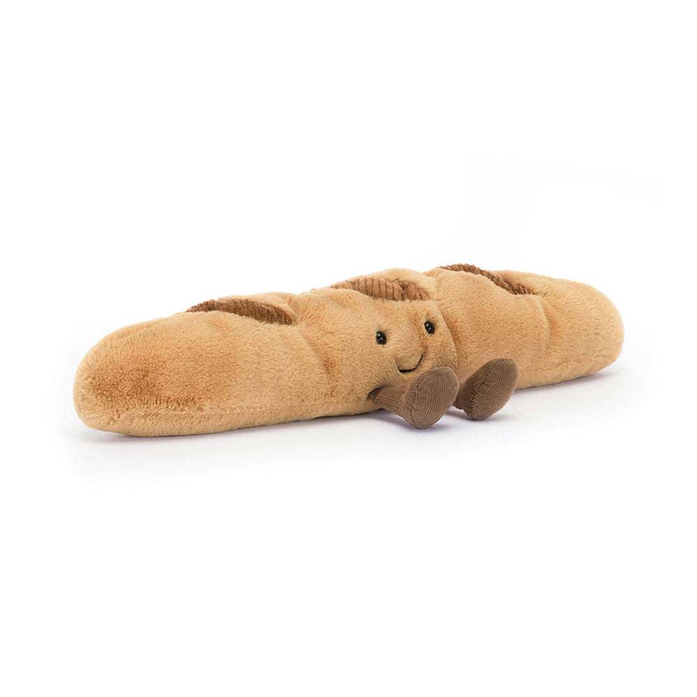 Tan plush baguette toy with smiling face and brown corduroy feet on white background