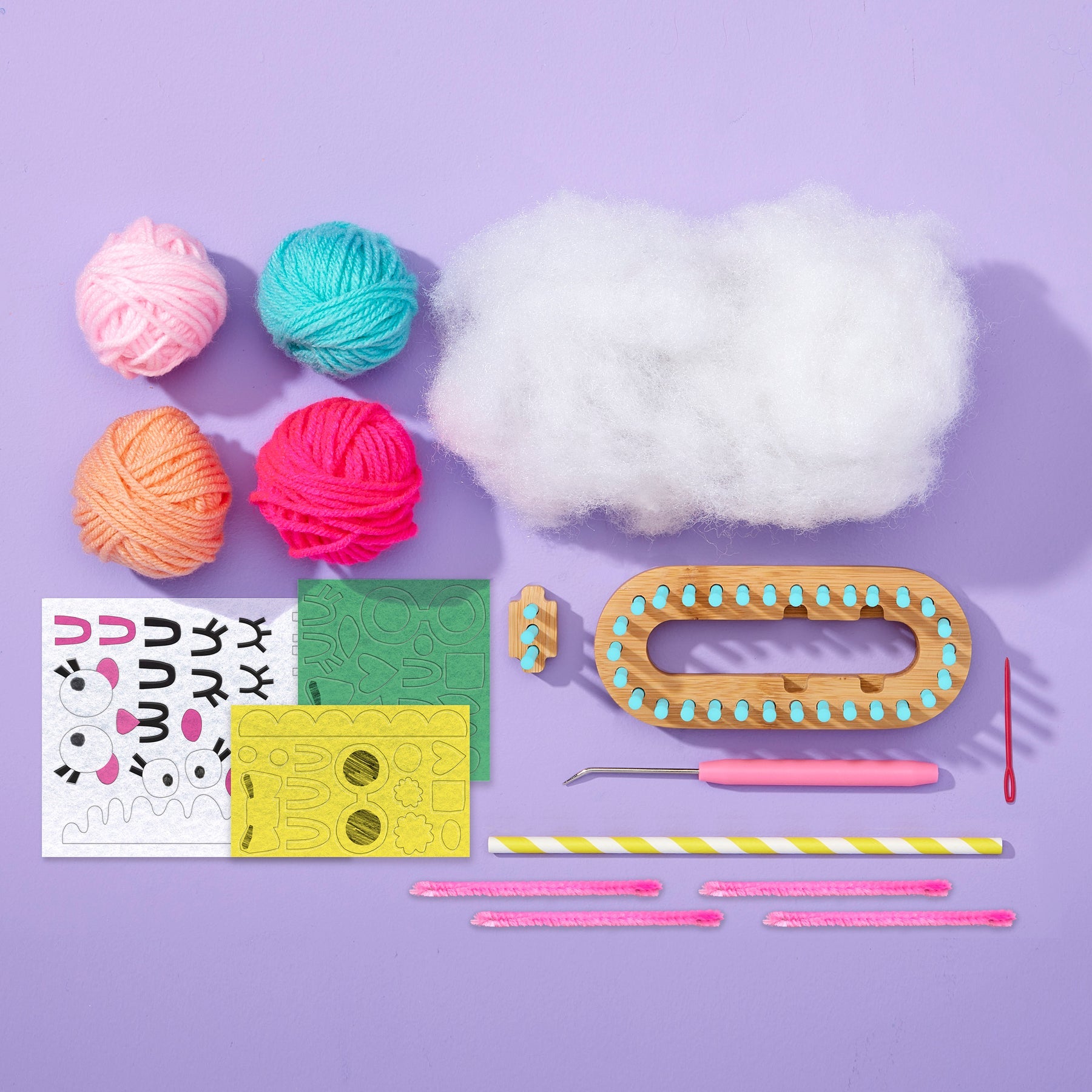 Knitting and crochet supplies including yarn, a loom, and tools on a purple background