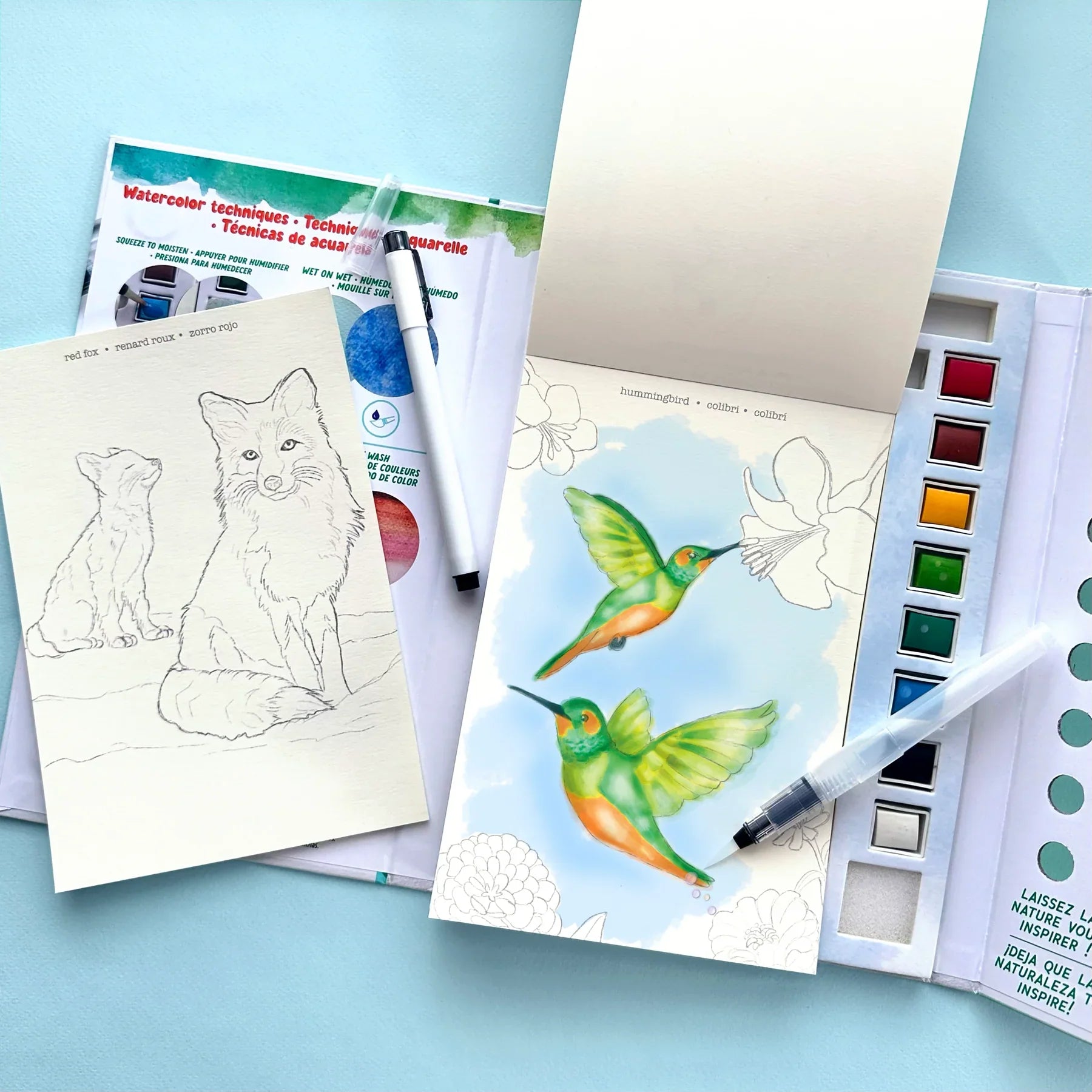 Watercolor journal set with animal coloring pages, hummingbird artwork, and watercolor paint palette