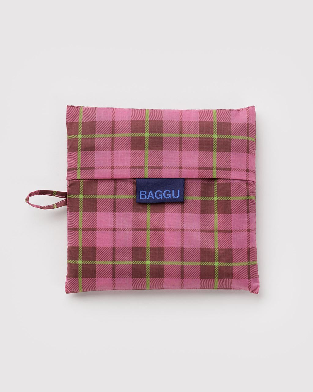 Baggu reusable bag folded into a compact pouch with pink, burgundy, and lime green tartan pattern