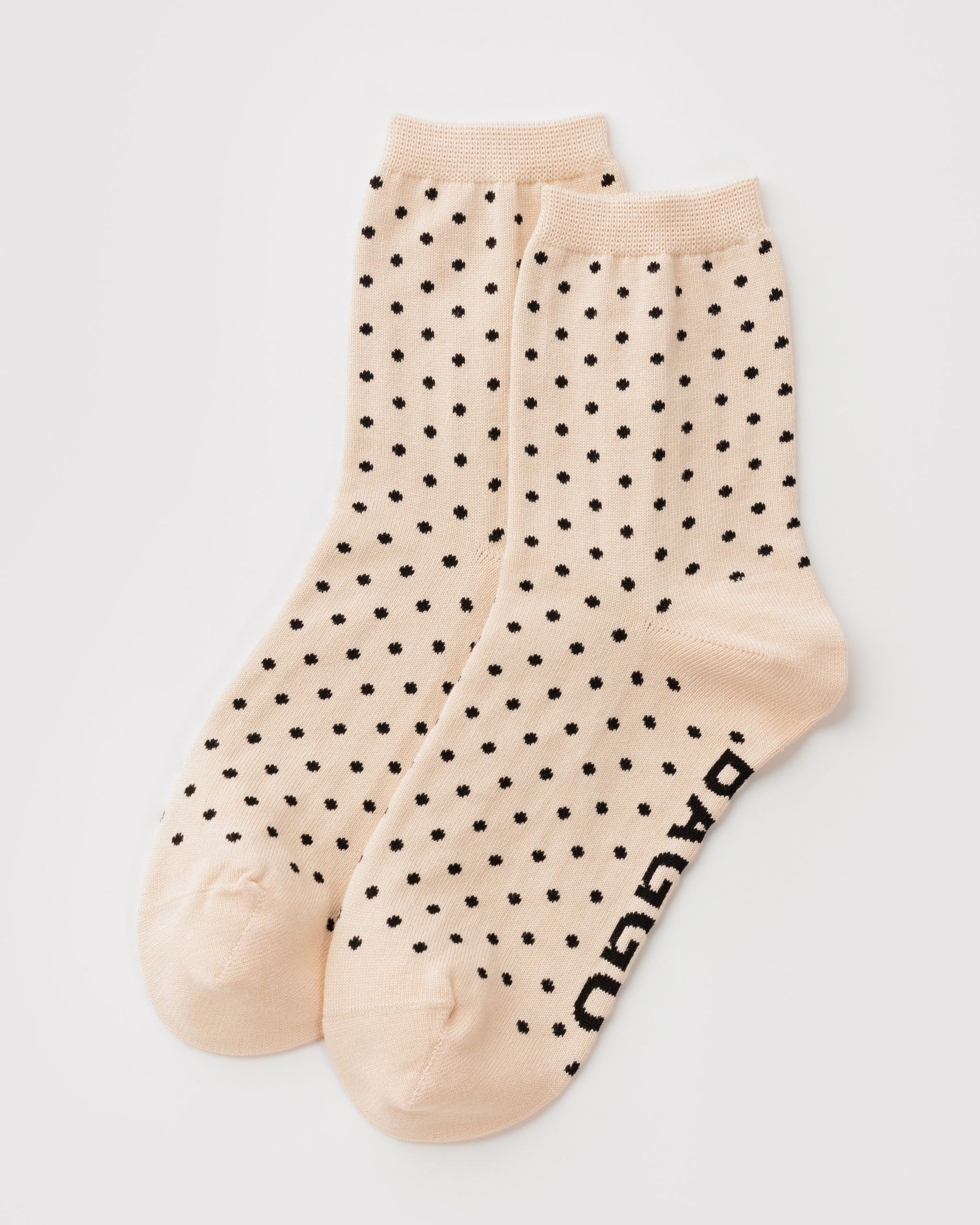 Baggu crew socks in cream with black micro polka dot pattern on white background