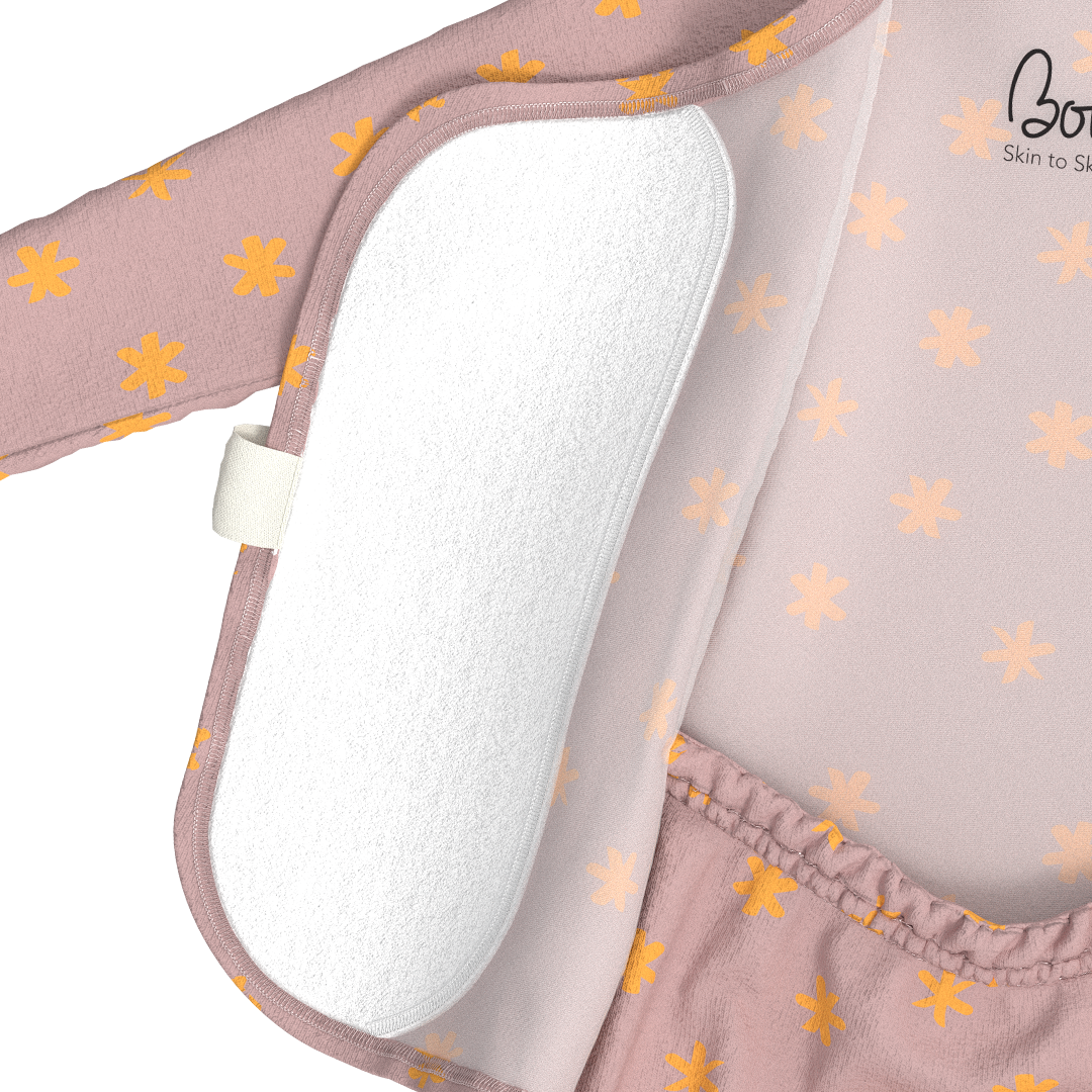 Bonsie skin-to-skin footie in blush pink with gold snowflake pattern showing velcro access panel detail