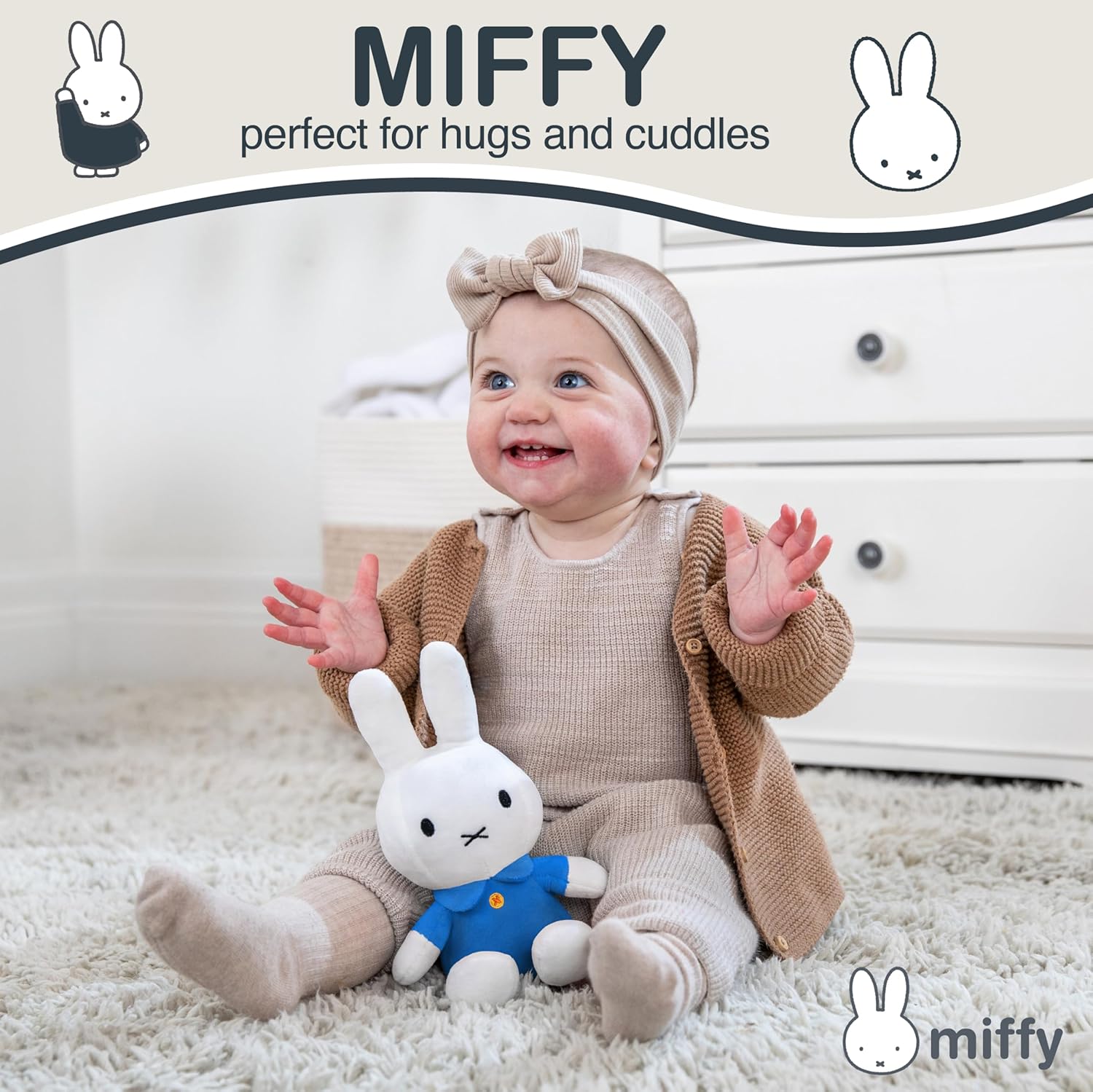 Smiling baby in beige knit outfit holding white Miffy bunny plush in blue dress