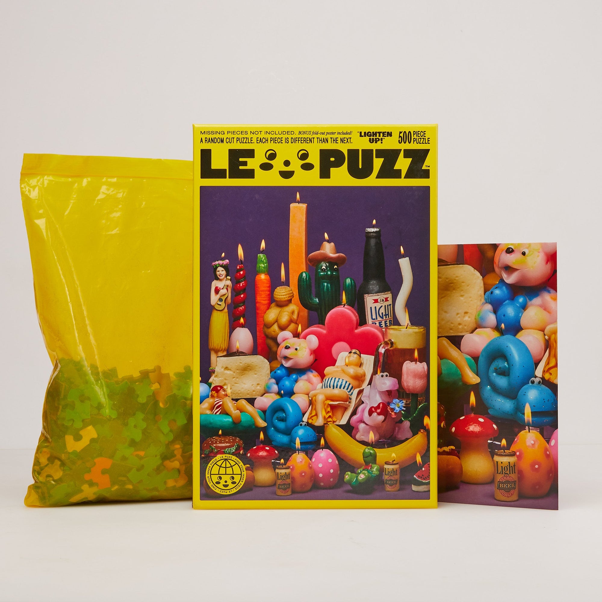 Le Puzz Lighten Up 500-piece puzzle box with yellow bag and fold-out poster on white background