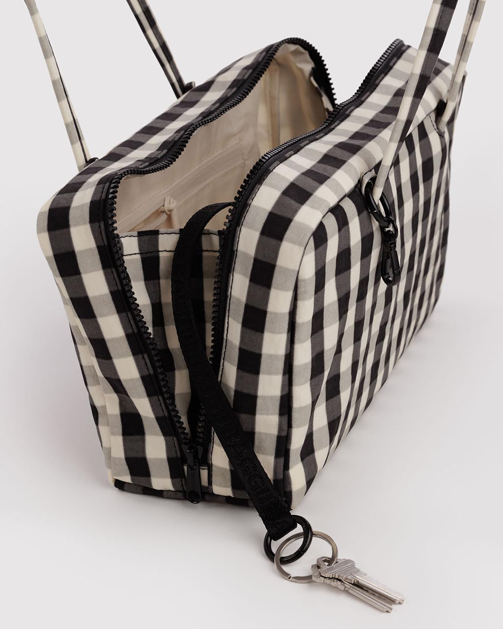 Open Baggu nylon bowler bag in black and cream gingham with keys attached to strap