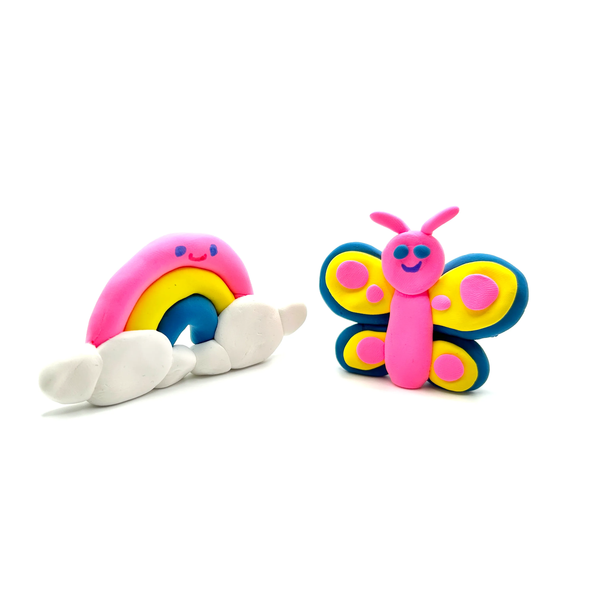 Colorful clay rainbow with clouds and butterfly craft made from air-dry clay on white background