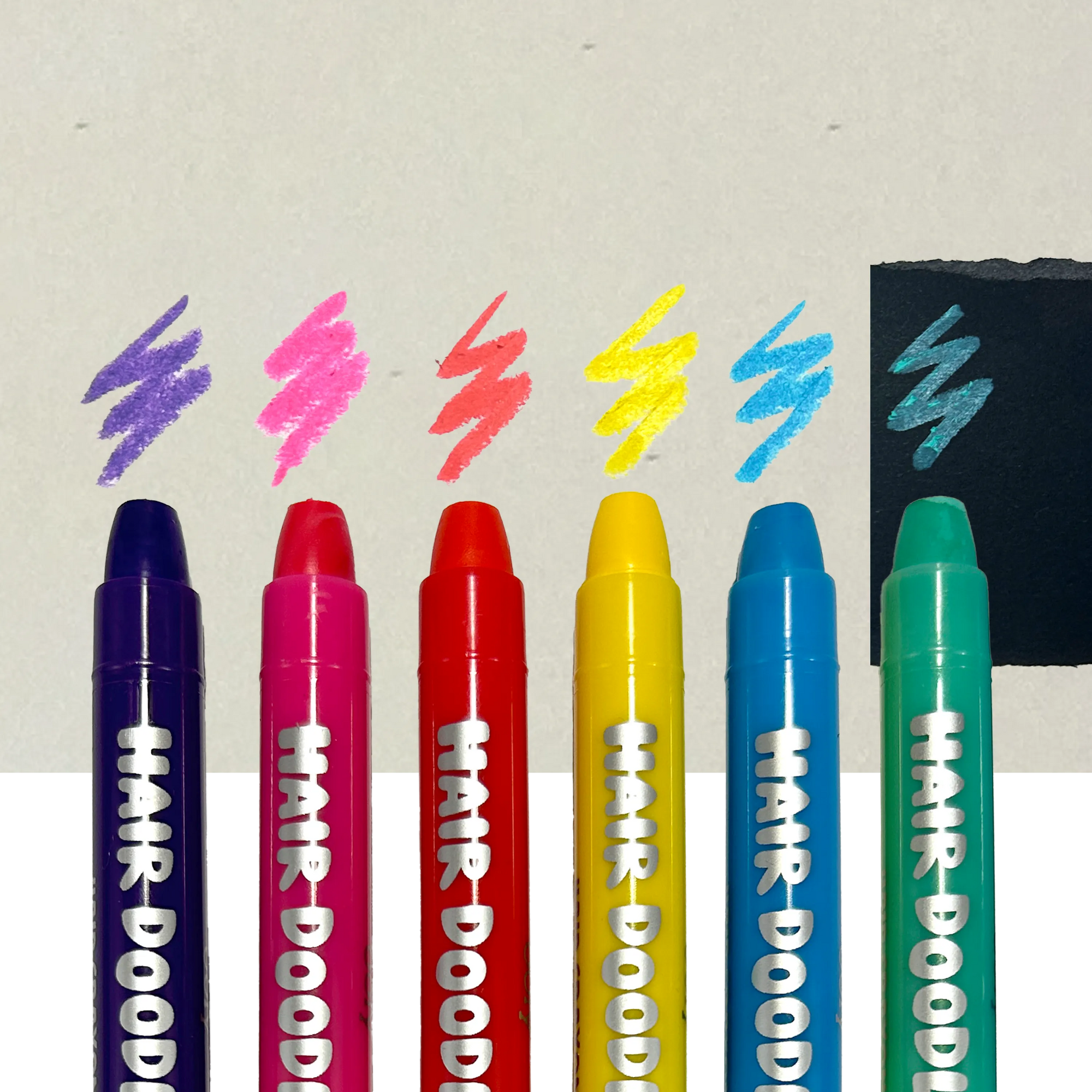 Six colorful Hair Doodler hair crayons by Ooly arranged in a row with color swatches above each