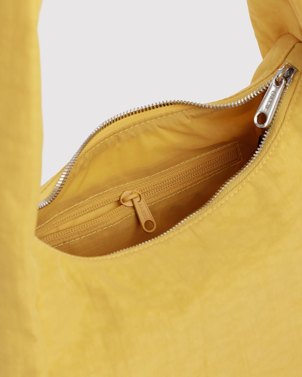 Interior view of Baggu Small Nylon Meringue Bag in sunflower yellow showing inner zipper pocket