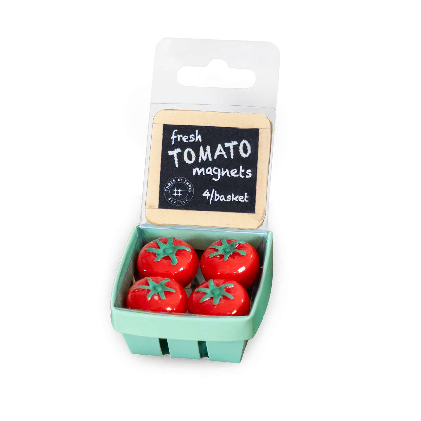 Set of four red tomato-shaped magnets in green plastic basket with product packaging