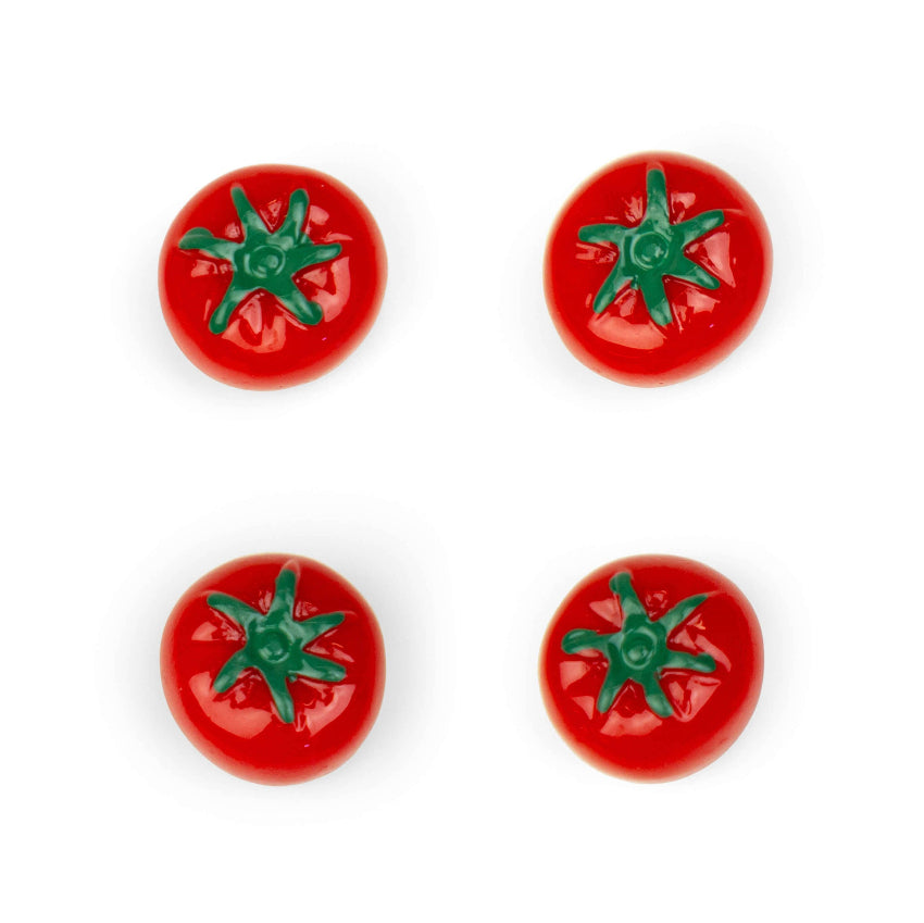 Four red tomato-shaped refrigerator magnets with green star tops arranged on white background