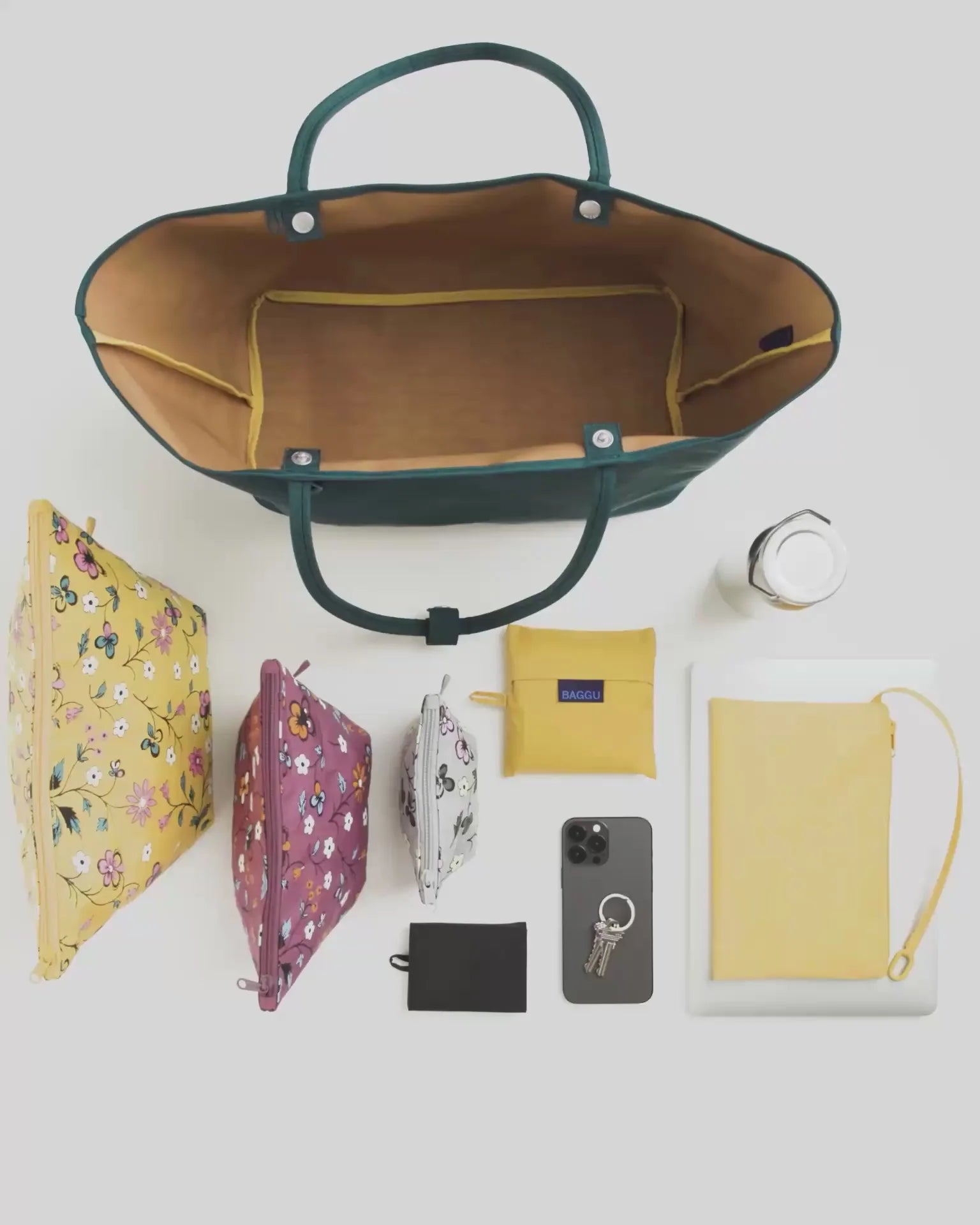Open deep sea teal Baggu reversible tote bag displayed overhead with coordinating accessories arranged below