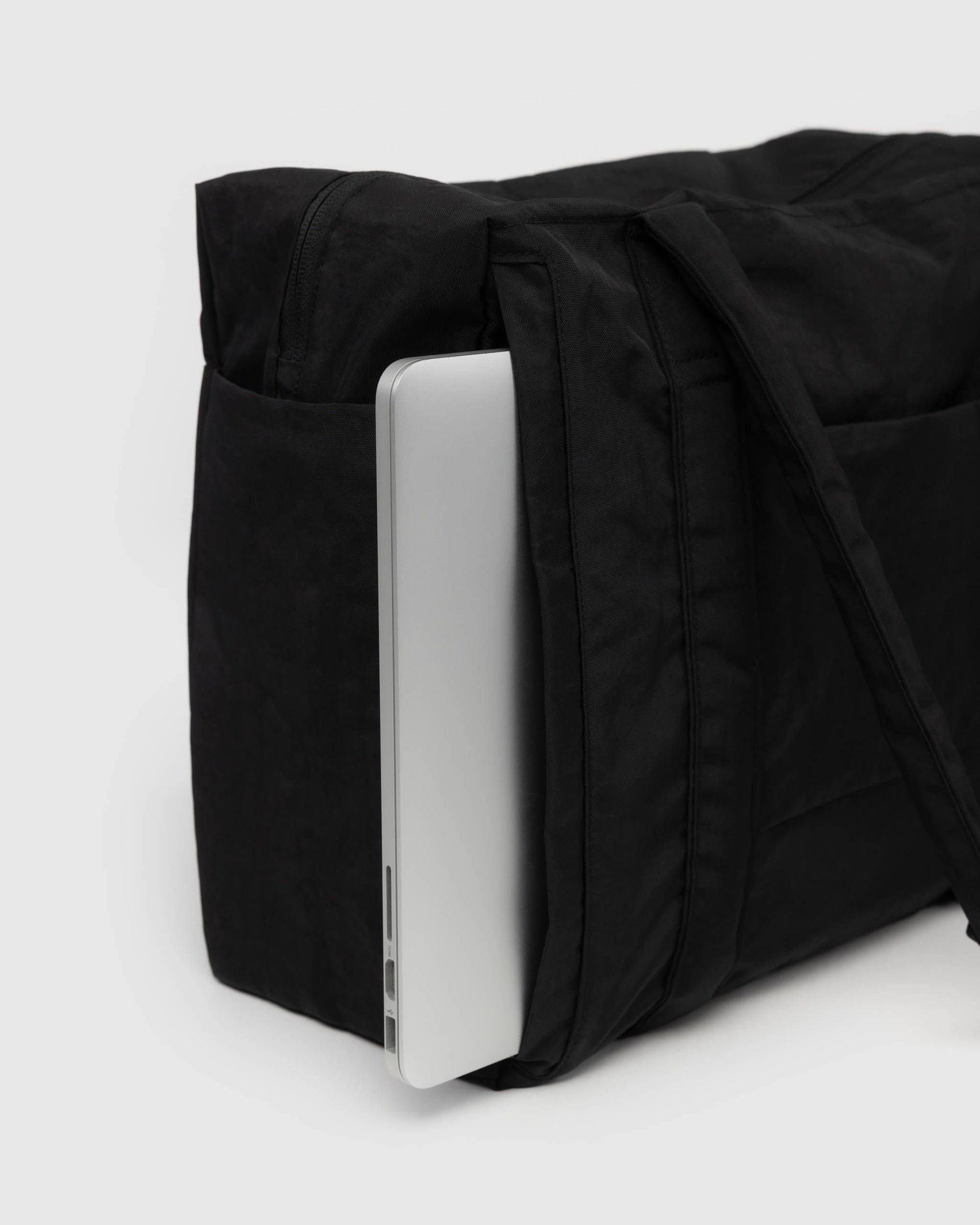 Black quilted carry-on bag with silver laptop compartment visible on side
