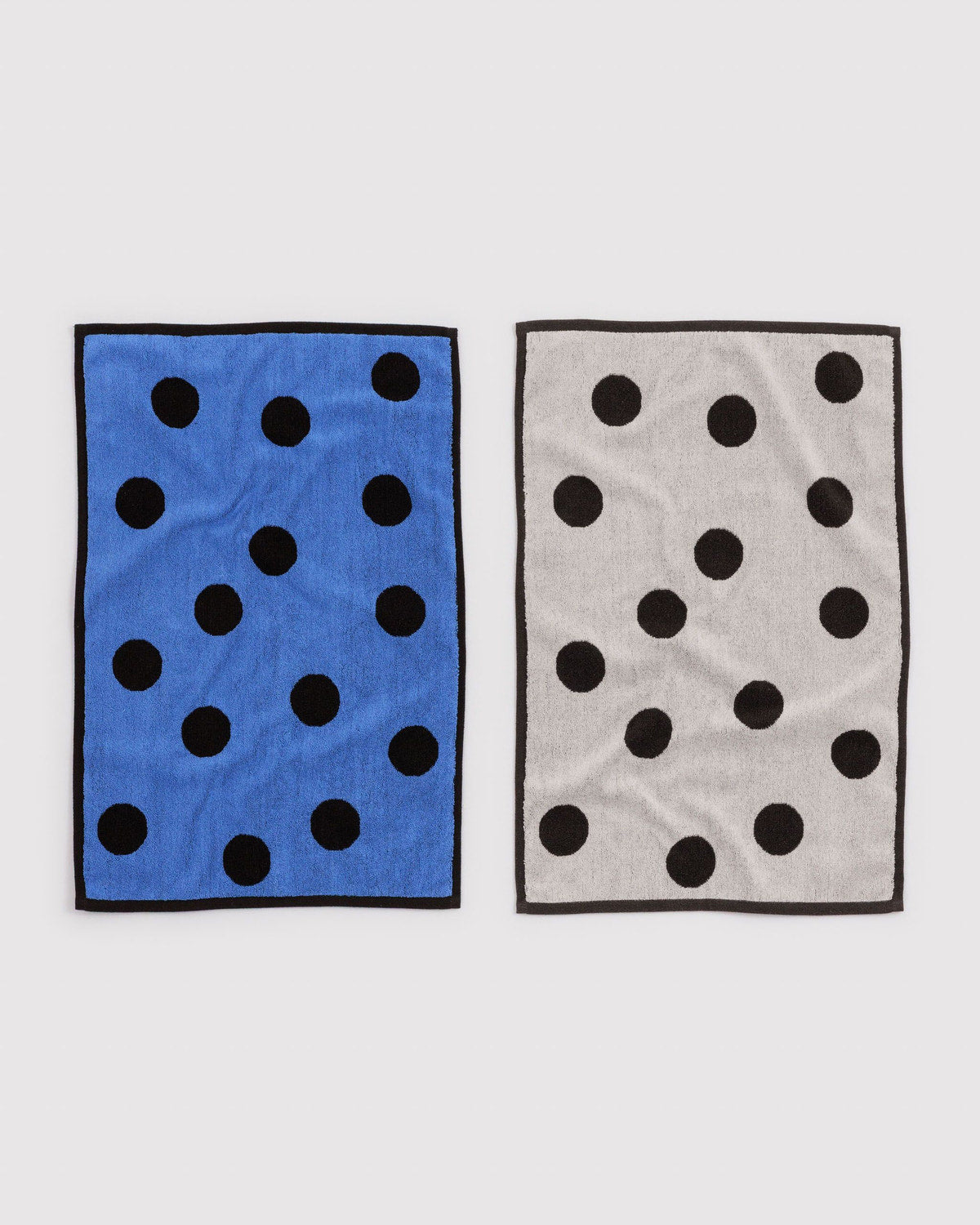 Set of two polka dot hand towels in blue and grey with black dots and border