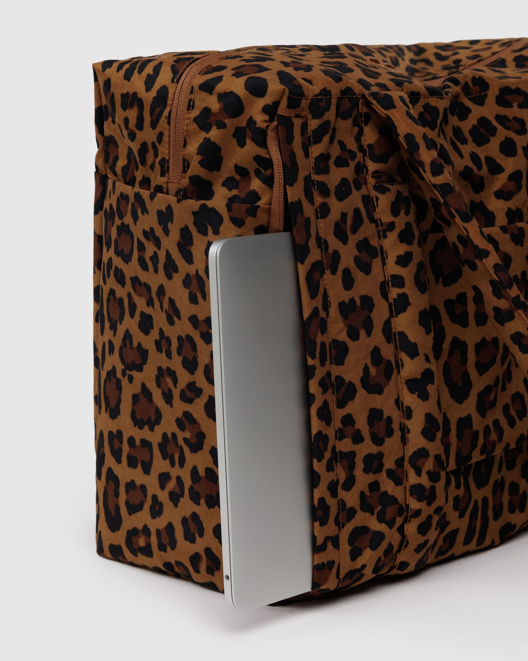 Leopard print carry-on bag with laptop compartment shown partially open on white background