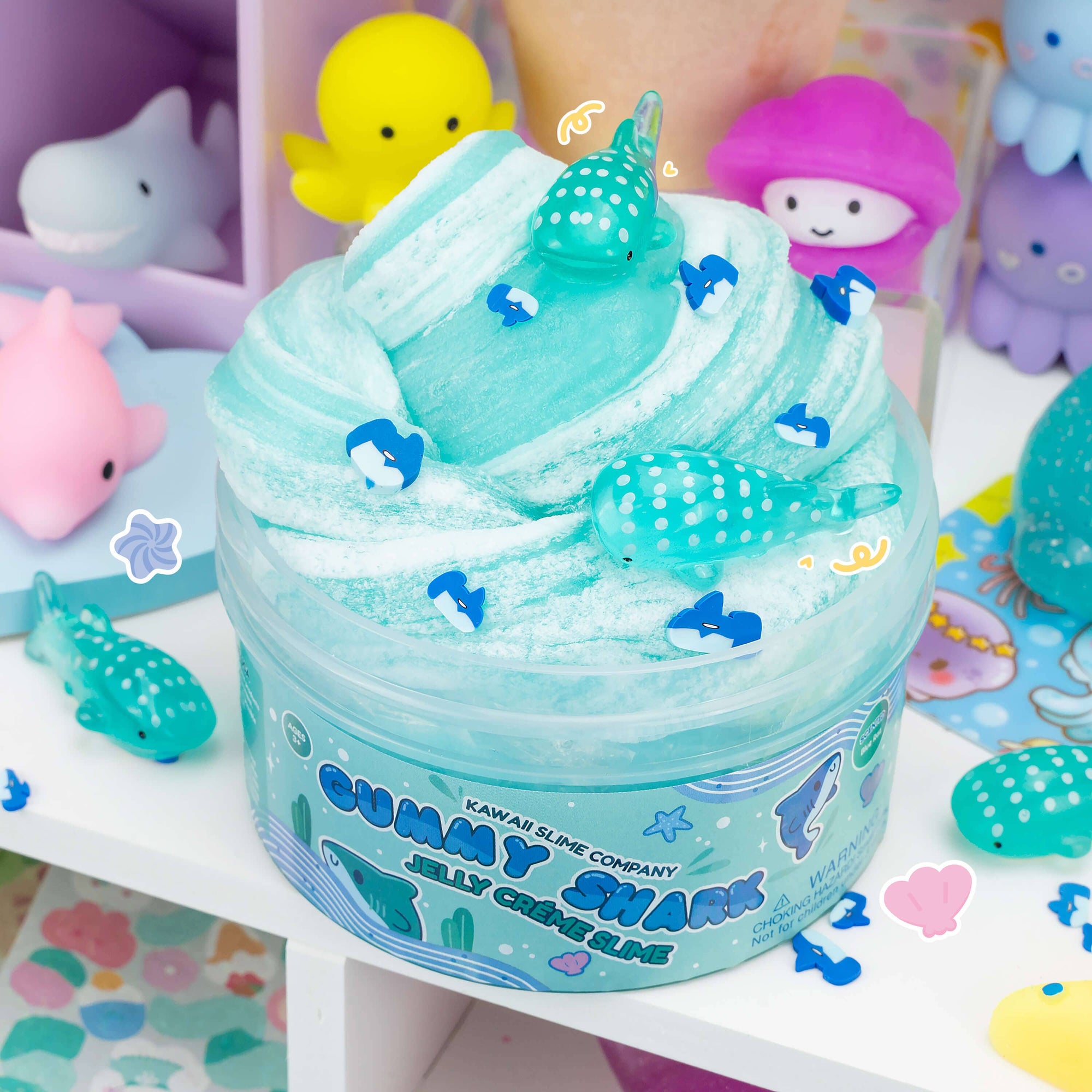 Kawaii Slime Company Gummy Shark Jelly Crème Slime in teal with shark charms and narwhal figurines
