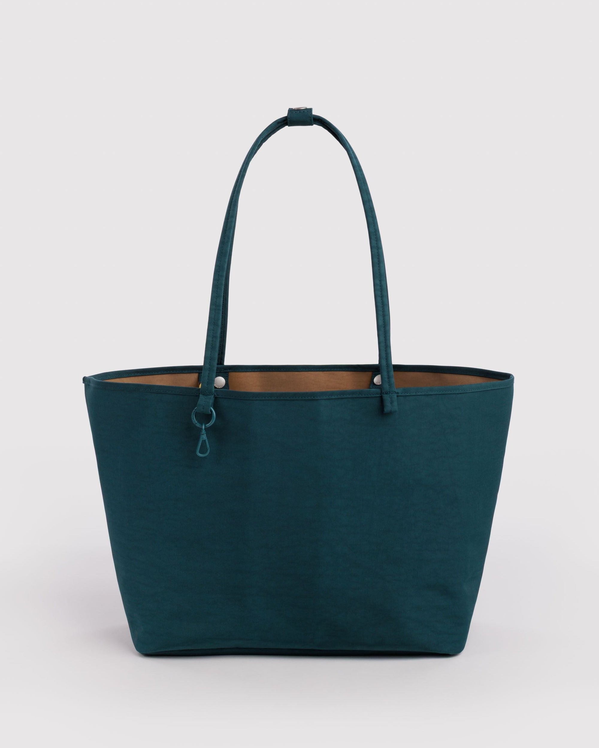 Large teal nylon reversible tote bag with tan interior lining and slim shoulder straps