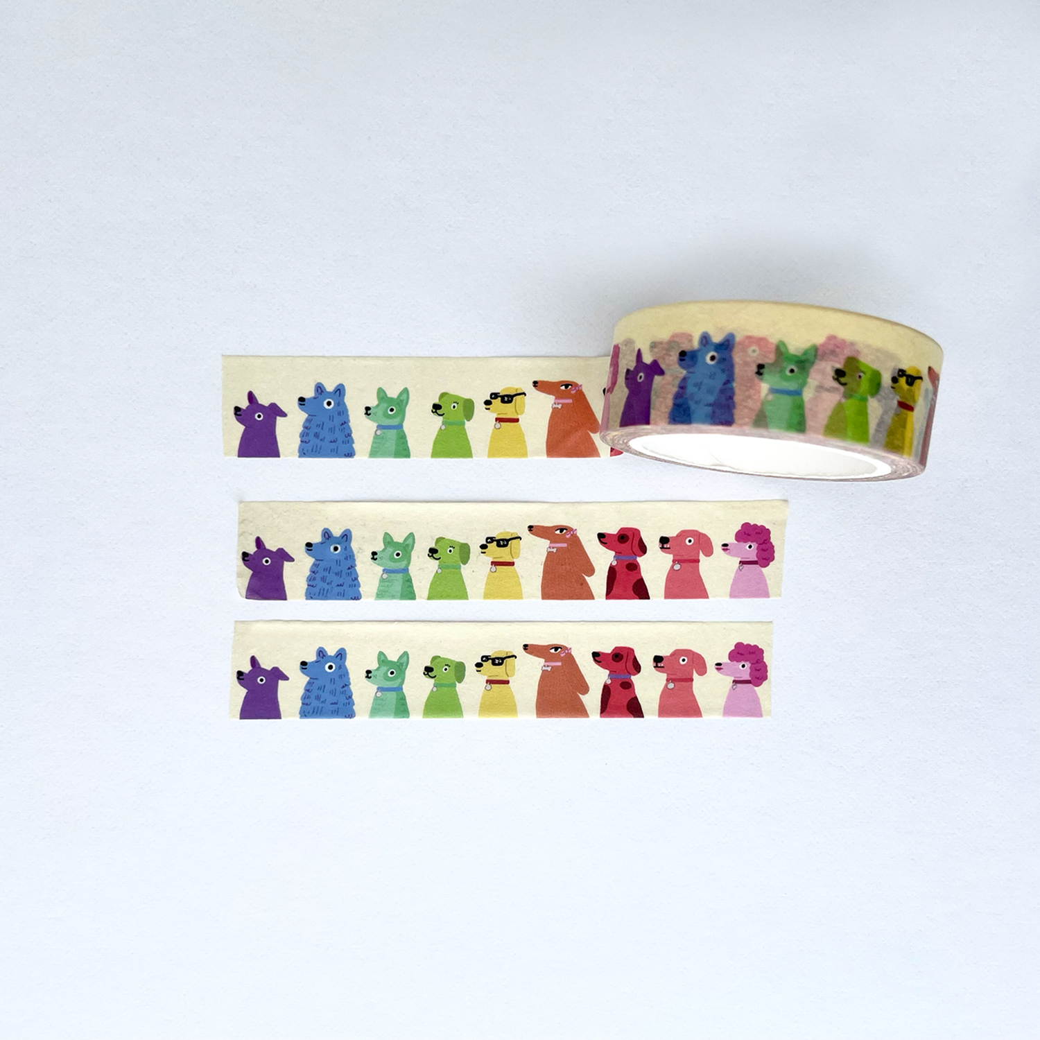 Rainbow colored washi tape featuring cute cartoon dogs in various colors arranged in a row