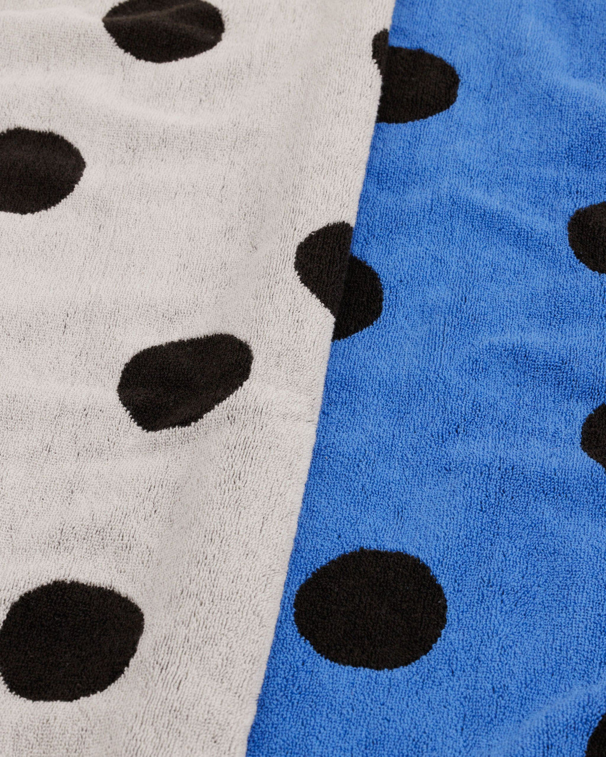 Close-up of two polka dot towels in white and blue with black dots side by side