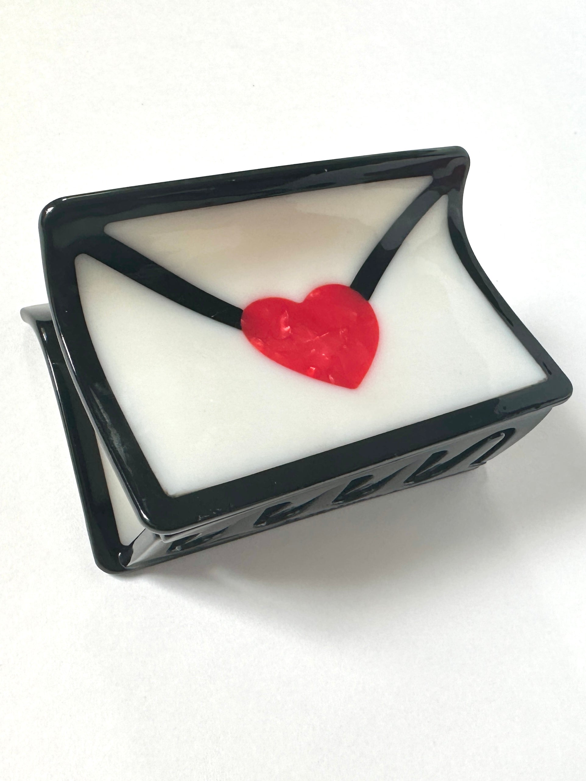 Black hair claw clip shaped like envelope with red heart seal