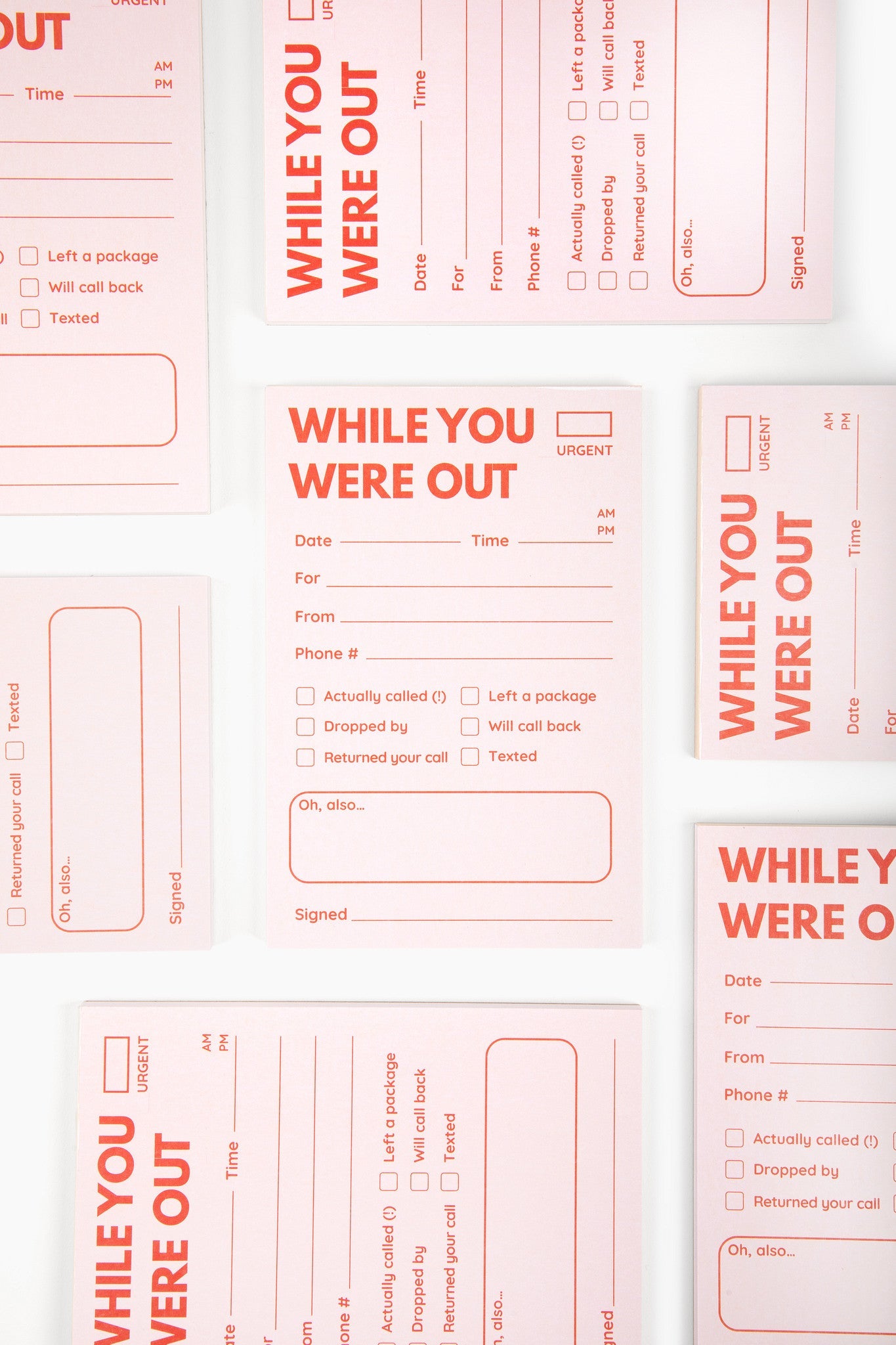Coral colored While You Were Out message notepads with fill-in fields for phone messages